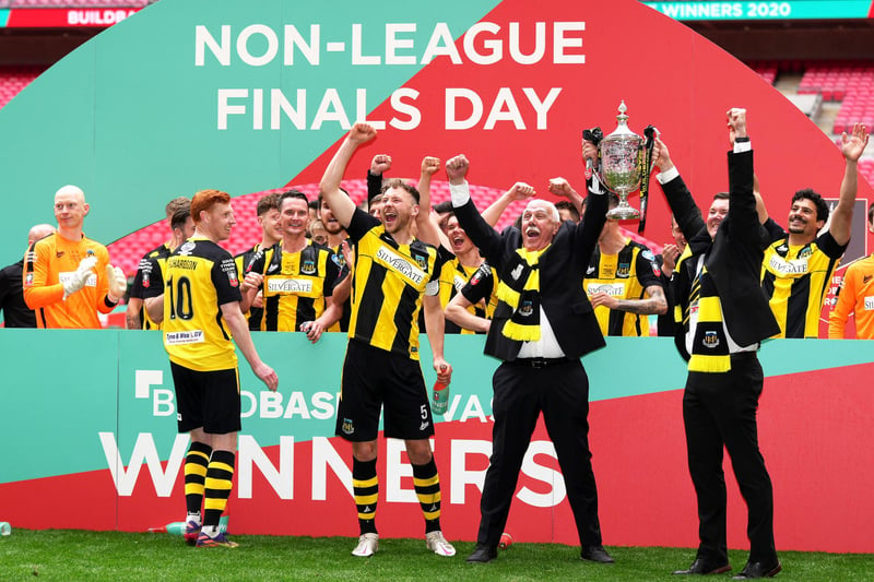 Hebburn Town's Michael Richardson (left), Hebburn Town's Louis Storey and chairman Vincent Pearson celebrate with players and staff with the Buildbase FA Vase 2019/20 trophy after victory in the Final at Wembley Stadium, London.