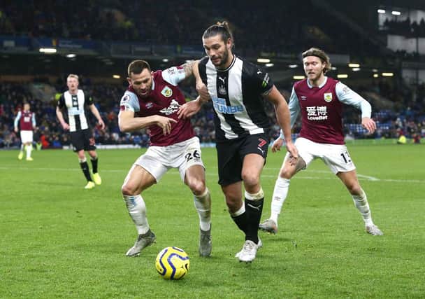 BURNLEY, ENGLAND - DECEMBER 14: Andy Carroll of Newcastle United protects the ball from Phil Bardsley of Burnley and Jeff Hendrick during the Premier League match between Burnley FC and Newcastle United at Turf Moor on December 14, 2019 in Burnley, United Kingdom. (Photo by Jan Kruger/Getty Images)