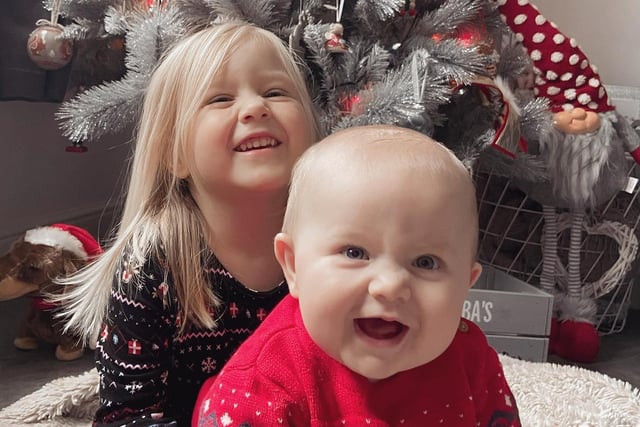 Myles and big sister Alba have a giggle under the tree.