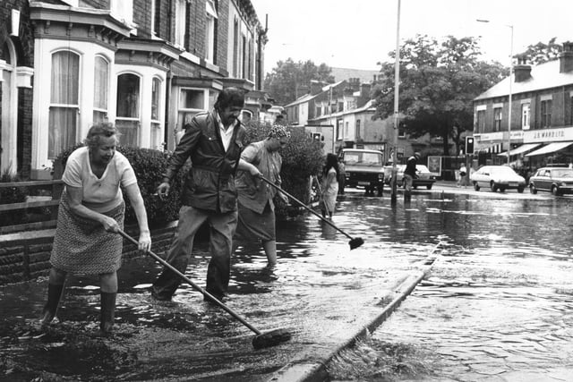 Neighbours work to keep the water away from their houses after flooding hits Abbeydale Road, at the junction with London Road, Sheffield, in August 1988. Pictured here are Mrs Wooley, Mrs Ward and Mr Majid. Mrs Wooley said: "It was only by opening a manhole cover outside the house that we saved the lower floor."