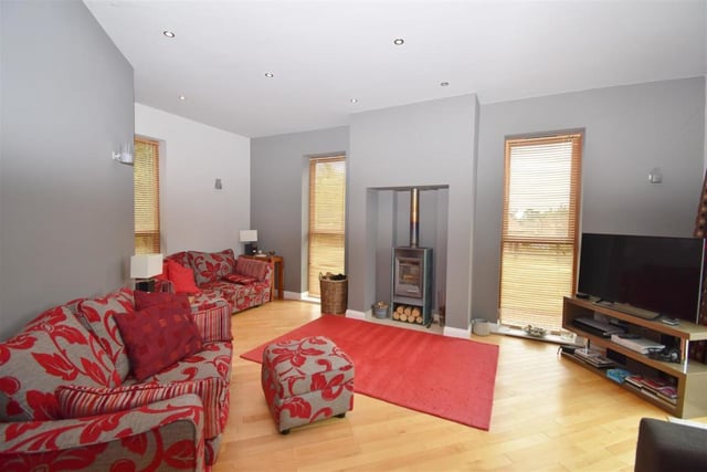 The house might be big, but this a homely lounge, complete with an impressive log-burner. There are windows to the front, side and back, while sliding pocket-doors open to the rear terrace and paved patio area.