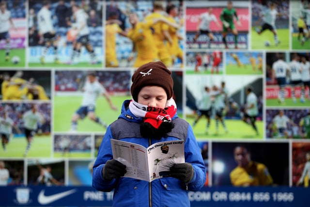 A young fan checks out the matchday programme ahead of United's FA Cup fourth round tie against Preston North End at Deepdale in January 2015.
