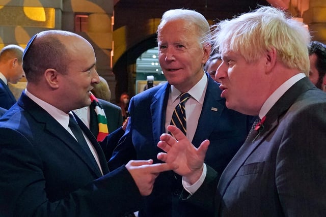 Israel's Prime Minister Naftali Bennett (L), US President Joe Biden (C) and British Prime Minister Boris Johnson (R) chat at the reception.
