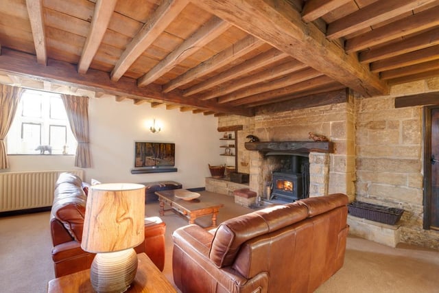 The lounge's centrepiece is its inglenook fireplace containing an Aga multi-fuel burner with a timber mantel, stone surround and tiled hearth.