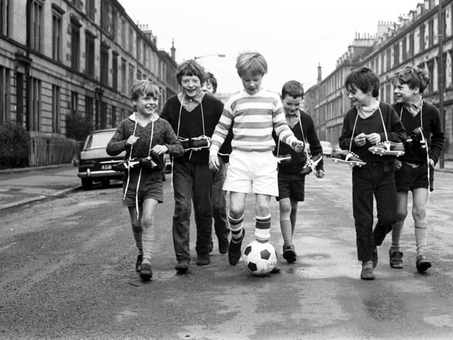 Little boys show off their Xmas presents (including new football boots, a football and a Celtic strip) in McCulloch Street, Pollokshields Glasgow in December 1970.