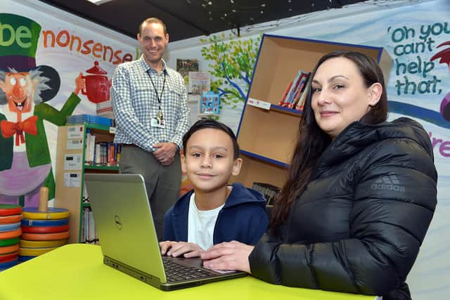 Assistant headteacher James Mills, with Castro Hart-Richards and Vikki Hart, pictured with a laptop at Athelstan Primary School.