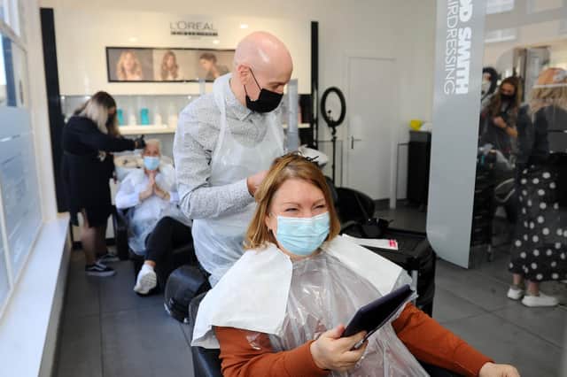 Rod Smith tends to customer Margaret Murray's hair as Rod Smith Hairdressing reopens