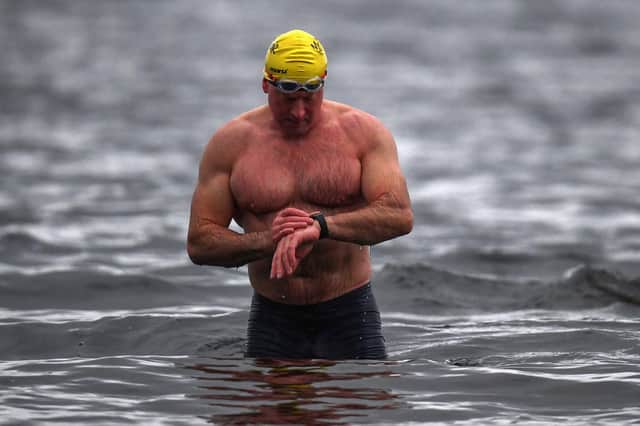 Open water swimming enthusiasts enjoy an early morning swim in Loch Lomond in Trossachs, Scotland.