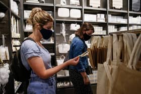 Customers wear face masks while shopping (Photo by Hollie Adams/Getty Images)