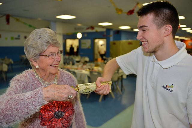 Kathleen Hill (88) from Boldon Colliery pulls a cracker with Andrew Reynolds (16) from Boldon Comprehensive School during the Christmas party three years ago.