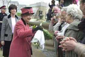Queen Elizabeth II receiving flowers from the crowds who came to see her in Sheffield during her visit in 2003.