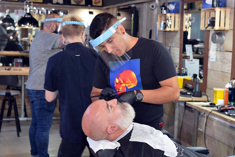 Barbers and hairdressers were busy on July 4, nicknamed Super Saturday because businesses reopened after lockdown. Barber Cosmin Sustar tends to a customer at Less Than Zero in Chesterfield.