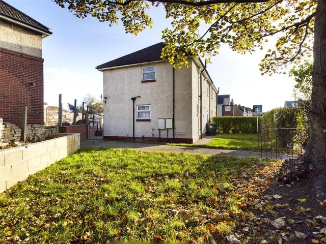 Hedge enclosed with wrought iron access gates, laid to lawn with raised flower bed, paved path and hard standing; access gate opening into the rear garden.