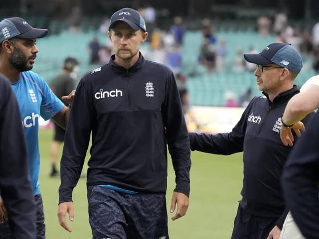 England's captain Joe Root, center, is patted on the back by team members at a the end of their Ashes cricket test match against Australia in Sydney, Sunday, Jan. 9, 2022. The Match ends in a draw. (AP Photo/Rick Rycroft)