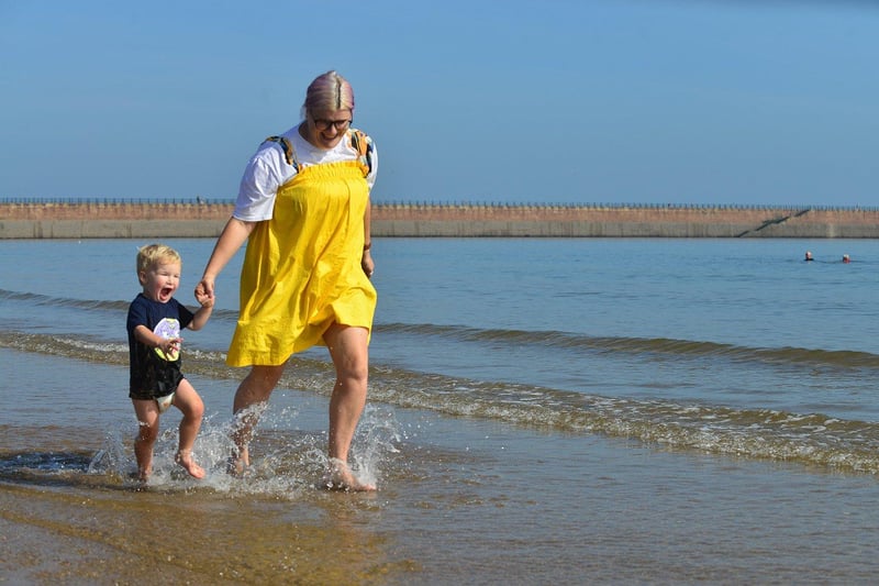 Jade Laws running at the water's edge with her son, Harris.