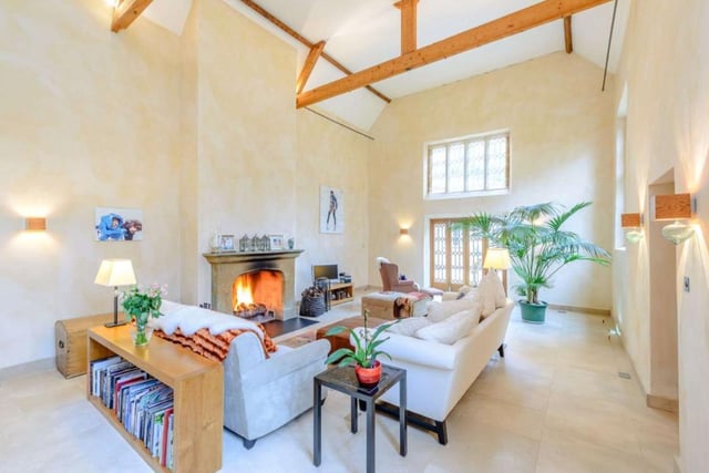 The vast sitting room area has grand, cathedral-like qualities which is enhanced by the sheer amount of natural light that fills the room from the full height mullioned windows and French doors.