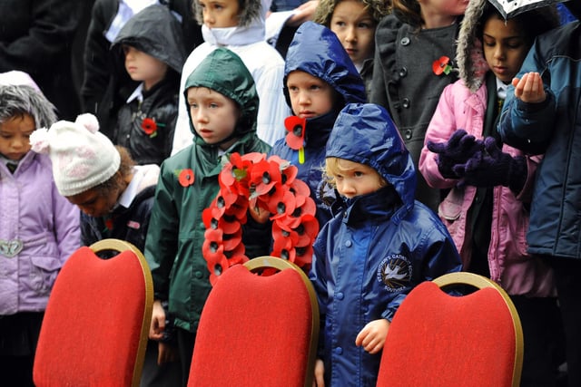 The Remembrance Sunday service held in The Guildhall Square Portsmouth followed by wreath laying at The Cenotaph and The World War Two Memorial in 2010. Young school children brave the heavy rain. Picture: Malcolm Wells (103698-7486)