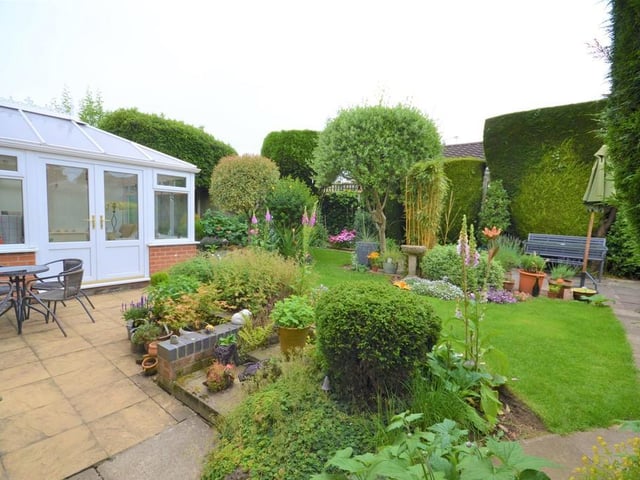 Rear garden - Wrought iron gates to either side of the property give access to a fully enclosed and private rear garden, having mature trees, shrubs and flowers frame various patio seating areas and well kept lawn, there is access back into the breakfast room and conservatory.