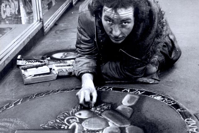 Pavement artist Mark Johns with his Christmas message in Fargate December 10, 1982