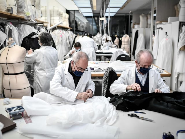 Employees work on couture garments