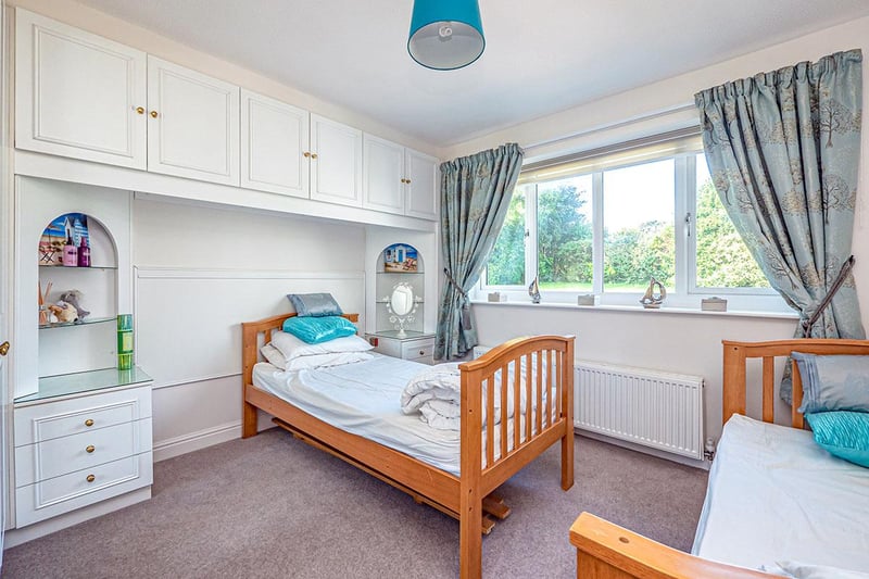 A rear-facing, double bedroom with built-in wardrobes and matching bedside cabinets.
