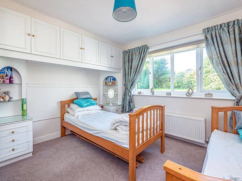 A rear-facing, double bedroom with built-in wardrobes and matching bedside cabinets.