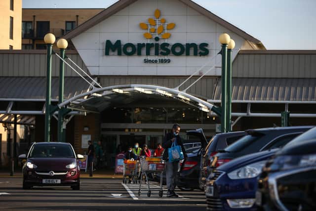 A shopper loads groceries into his car outside a Morrisons  (Photo by Hollie Adams/Getty Images)