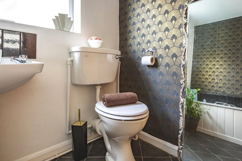 The bathroom is fitted with a white, three-piece suite comprising enamel bath with chrome effect mixer tap and shower attachment over, low flush WC and pedestal wash hand basin.