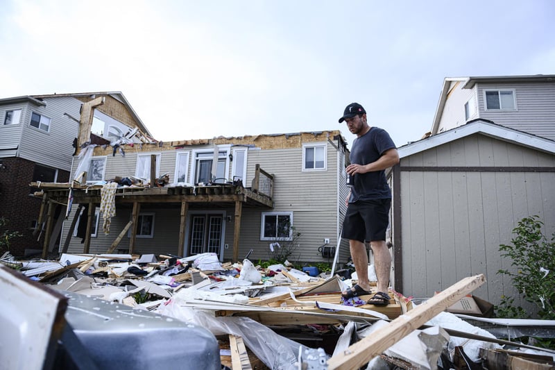 A resident surveys the damage left after a tornado touched down in his neighborhood, in Barrie, Ontario, on Thursday, July 15, 2021. (Christopher Katsarov/The Canadian Press via AP)