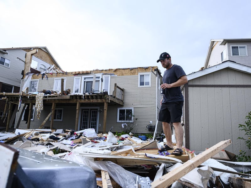 A resident surveys the damage left after a tornado touched down in his neighborhood, in Barrie, Ontario, on Thursday, July 15, 2021. (Christopher Katsarov/The Canadian Press via AP)