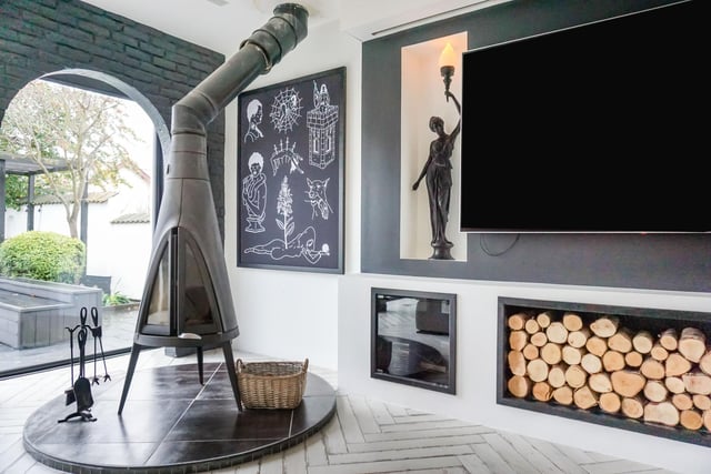 A raised circular tiled hearth with black leaded wood burner commands the lounge.