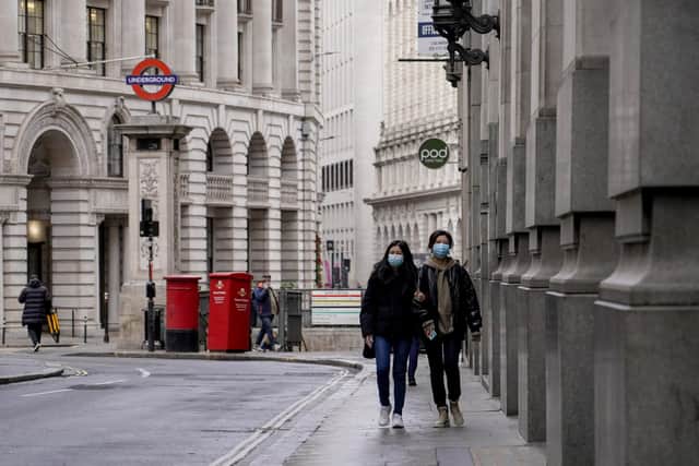 People wear face masks while walking in an empty street in the financial district, known as The City, in London, where Sheffield United face Fulham next week: Photo/Alberto Pezzali