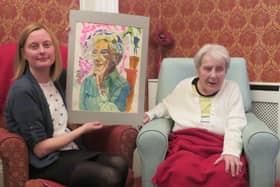 Sheffield artist Joyce Spurr presenting her painting of Enid Hattersley to Museums Sheffield curator Clara Morgan