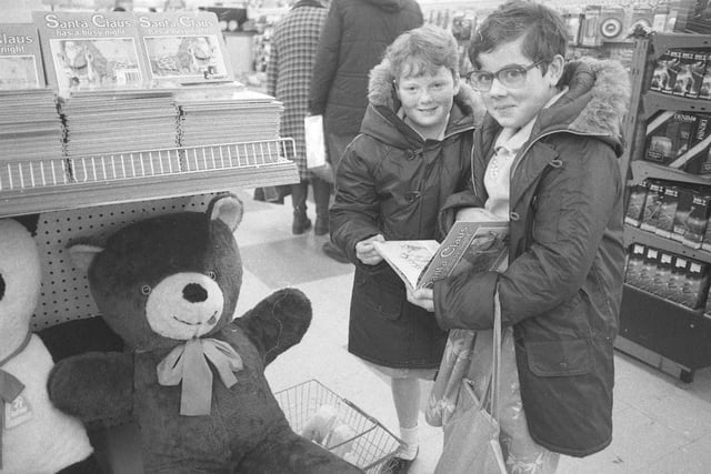 Two young shoppers look at books in one of the town centre shops, but who recognises the shop in question?