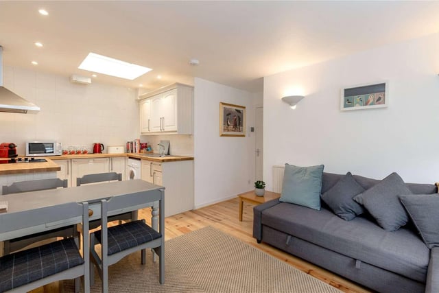The flat has modern styling with an open-plan living, dining and kitchen area