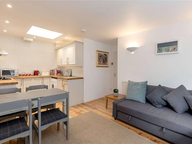 The flat has modern styling with an open-plan living, dining and kitchen area