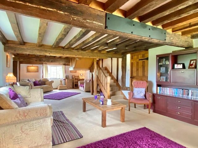 A fine entrance hallway, which features a piece of medieval graffiti, leads to this large lounge, which is full of character. It includes exposed beams and inset timber frames to the walls, plus windows on three sides.