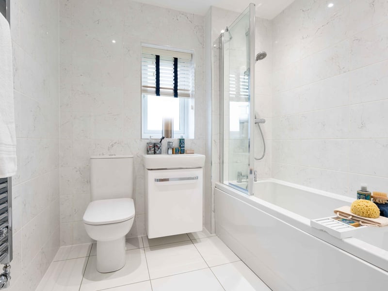 Family bathroom with white thre piece suite and over bath shower.