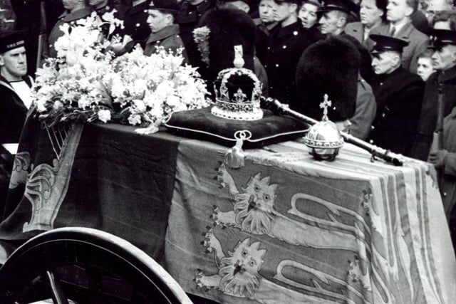 King George VI's coffin, on a gun carriage, draped in the Royal Standard and bearing the Crown, the Orb and the Sceptre, as it passes through the Windsor High Street, February 15, 1952