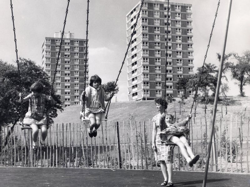 Children enjoying the swings in this playground at Herdings, Sheffield, 1969