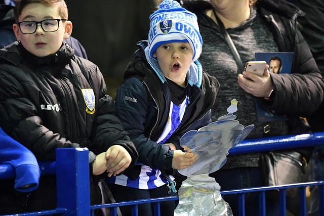 A young Wednesday fan holds aloft a home-made trophy ahead of the FA Cup fifth round tie with Manchester City at Hillsborough shortly before football was suspended due to the Covid-19 pandemic in March 2020.