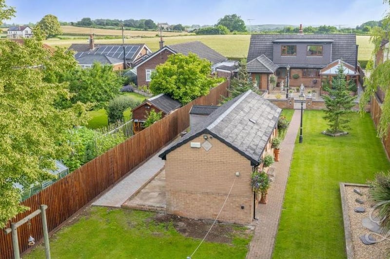 An aerial view from the back of the £600,000 property. It clearly shows the beautifully presented garden, manicured lawn and outbuilding.