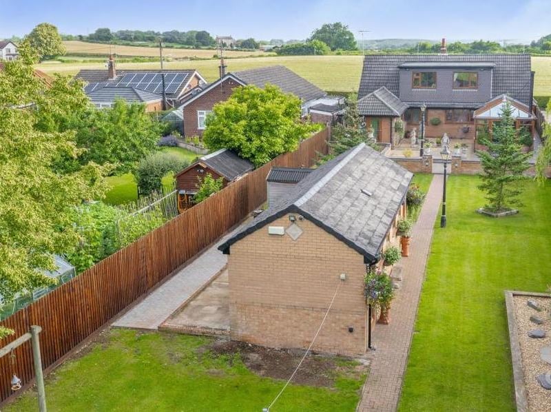 An aerial view from the back of the £600,000 property. It clearly shows the beautifully presented garden, manicured lawn and outbuilding.