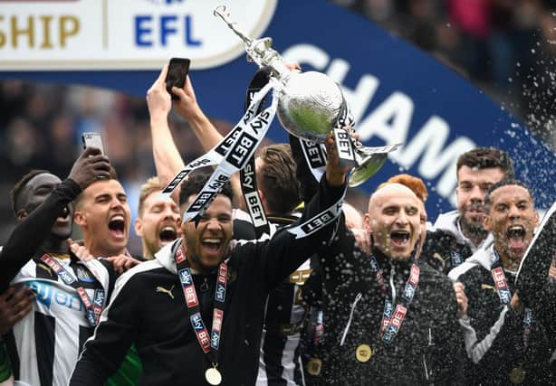 NEWCASTLE UPON TYNE, ENGLAND - MAY 07:  Newcastle United players Jamaal Lascelles (l) and Jonjo Shelvey lift the trophy after winning the Sky Bet Championship title after the match between Newcastle United and Barnsley at St James' Park on May 7, 2017 in Newcastle upon Tyne, England.  (Photo by Stu Forster/Getty Images)