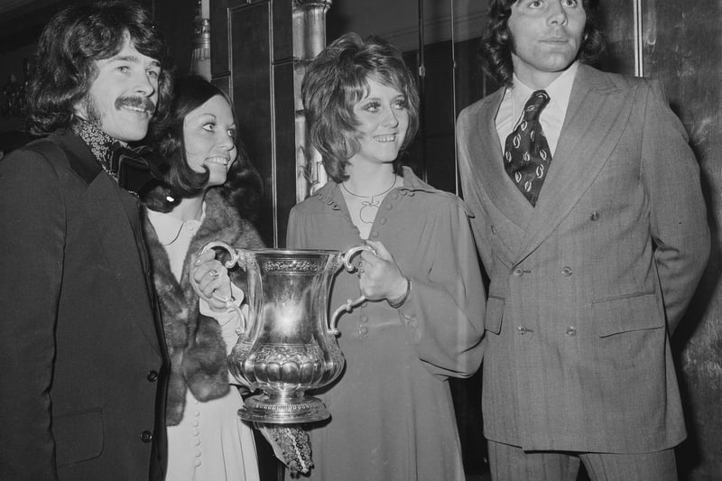 Ian Porterfield and Bobby Kerr celebrate winning the FA Cup with their wives, who are holding the trophy, on May 7, 1973.