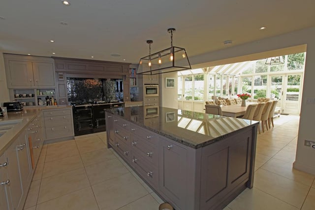 A range of appliances include a four-oven gas fired AGA with twin gas hob and stainless steel extractor over, integrated Neff dishwasher, Siemens combi oven, wine fridge, Hisense American fridge/freezer set in a unit flanked by pull out spice cupboards. There is a large central island with a granite worktop and further storage cupboards.