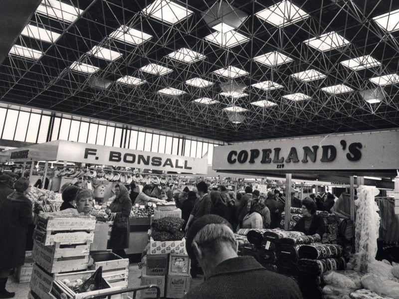 Fabric and fruit stalls side by side in the Sheaf Market