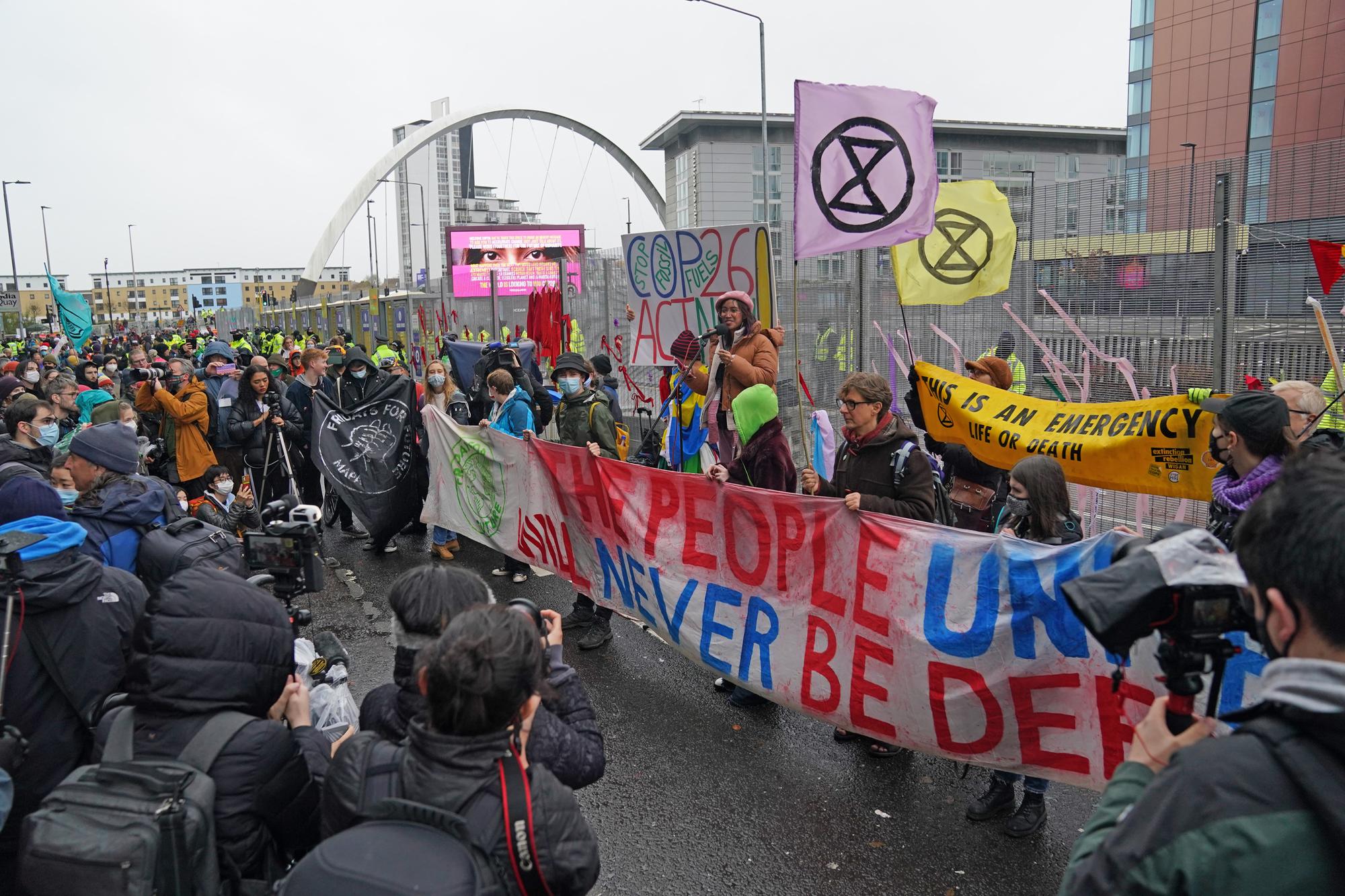 Climate Justice Activists at the Cop26 Gates asking delegates as they make final decisions, "Are You With Us Or With Fossil Fuels?" during the official final day of the Cop26 summit in Glasgow. Picture date: Friday November 12, 2021.