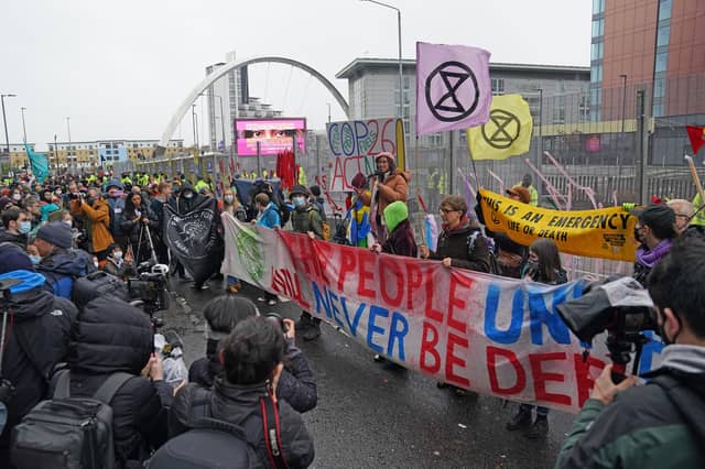 Climate Justice Activists at the Cop26 Gates asking delegates as they make final decisions, "Are You With Us Or With Fossil Fuels?" during the official final day of the Cop26 summit in Glasgow. Picture date: Friday November 12, 2021.