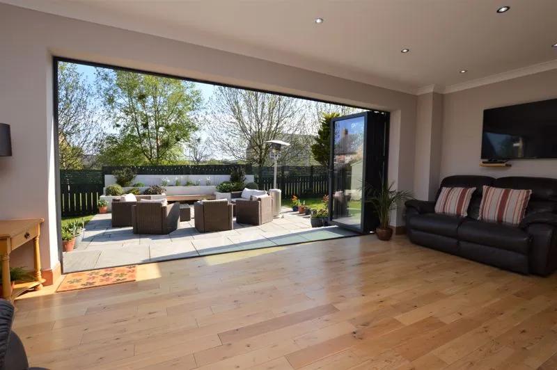 A garden room opens out through bi-fold doors to a patio area positioned in a sunny private space in the rear garden.
